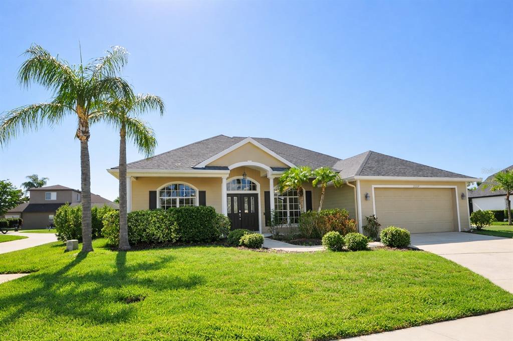 a front view of a house with a yard and potted plants
