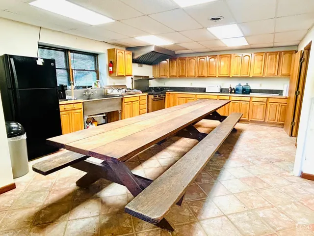 a kitchen with stainless steel appliances kitchen island granite countertop a refrigerator and sink