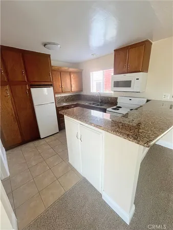 a kitchen with granite countertop a refrigerator sink and stove