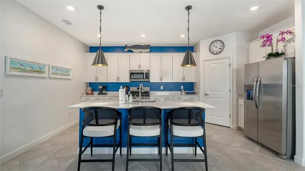 a kitchen with stainless steel appliances kitchen island granite countertop a sink a microwave and cabinets