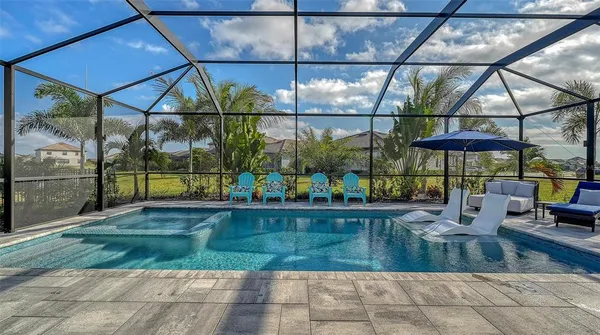 an aerial view of a swimming pool with outdoor seating