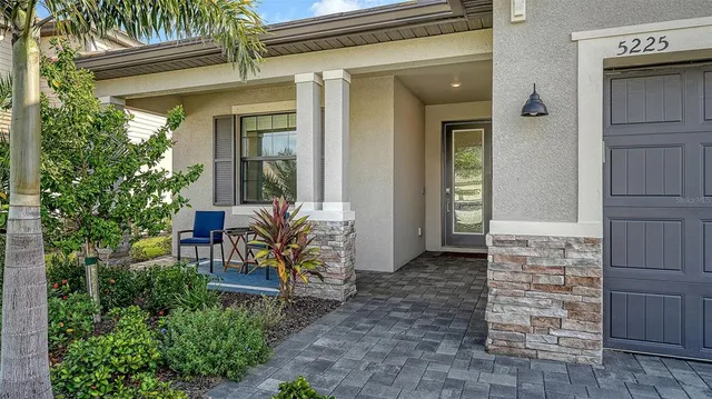 front view of a house with a chairs and table in a patio