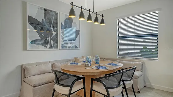 a kitchen with granite countertop a table chairs stainless steel appliances and cabinets