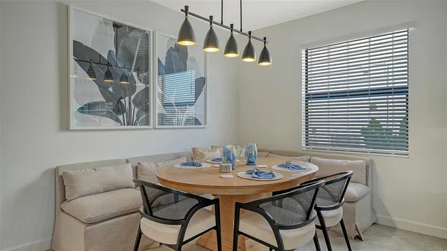 a kitchen with granite countertop a table chairs stainless steel appliances and cabinets