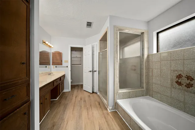 a spacious bathroom with a bathtub sink and mirror