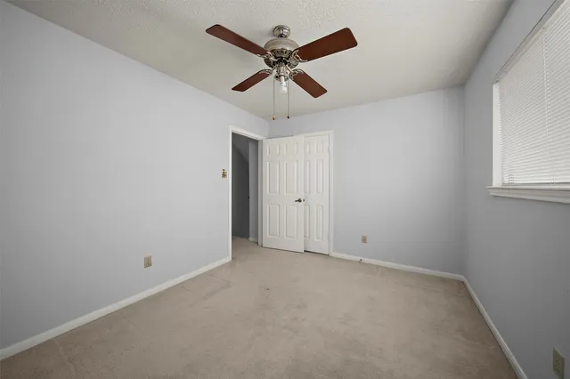 en empty room with window and ceiling fan