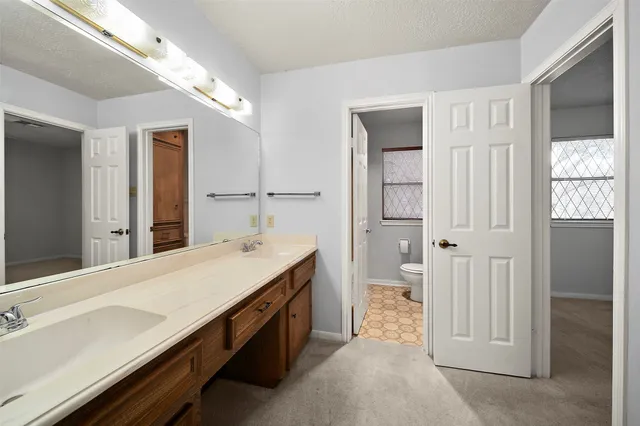a spacious bathroom with a granite countertop sink and a mirror