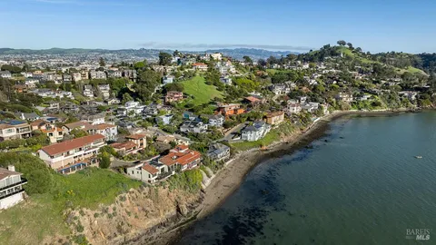 an aerial view of a house with swimming pool and glass top table and chairs