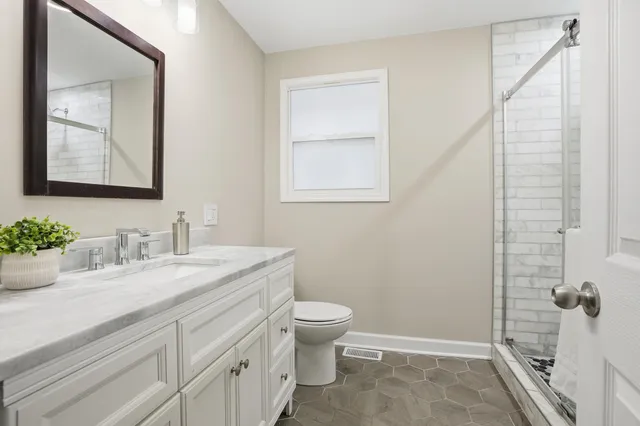 a bathroom with a granite countertop sink toilet and shower