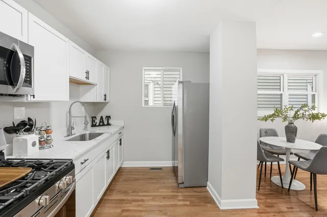 a kitchen with stainless steel appliances a sink stove and cabinets