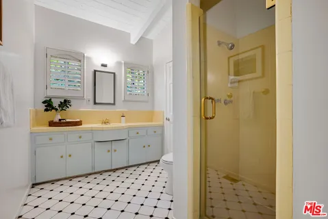 a spacious bathroom with a sink a mirror a shower and vanity