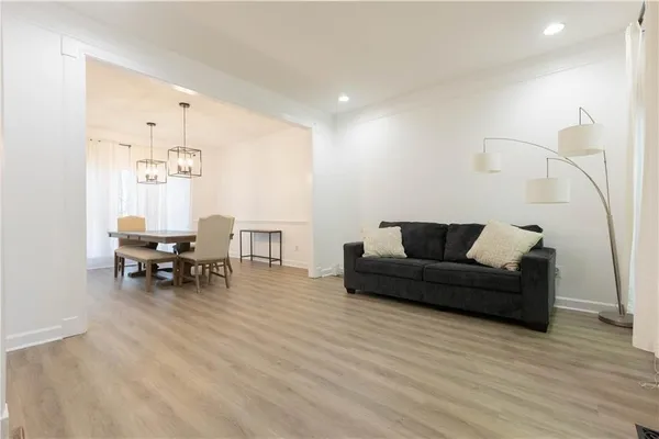 a living room with furniture and a dining table with kitchen view