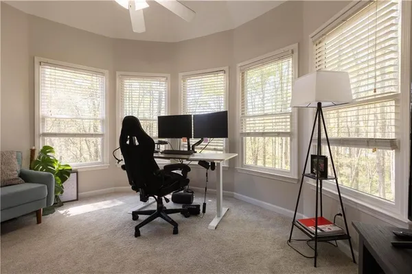 a view of a workspace with furniture and a window