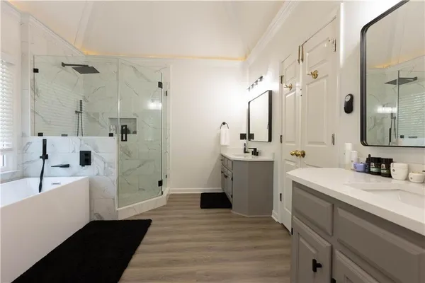 a bathroom with a sink a toilet a mirror and shower