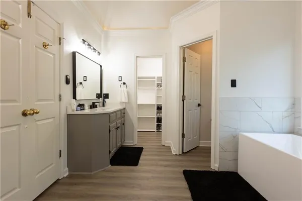 a bathroom with a tub sink shower and mirror