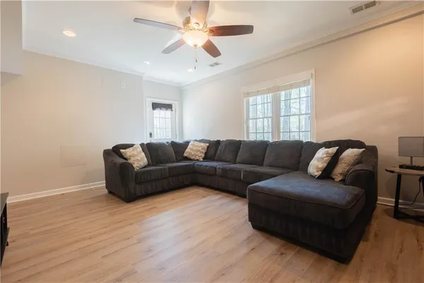 a living room with furniture and a ceiling fan