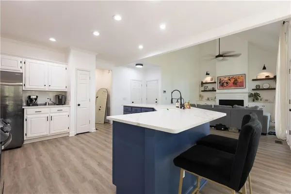 a kitchen with kitchen island a stove a sink a refrigerator and cabinets
