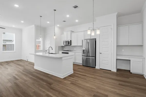 a kitchen with kitchen island white cabinets and stainless steel appliances