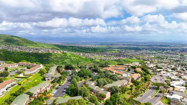 an aerial view of residential houses with outdoor space and trees