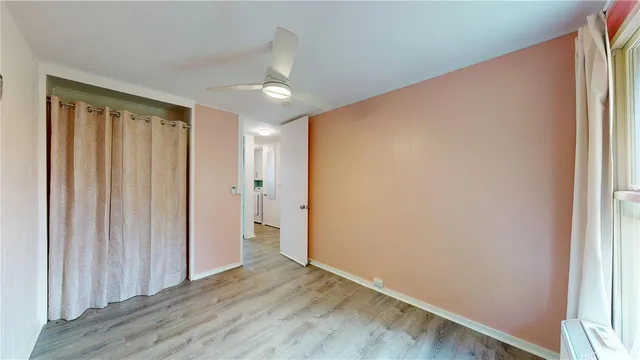 an empty room with wooden floor and a window