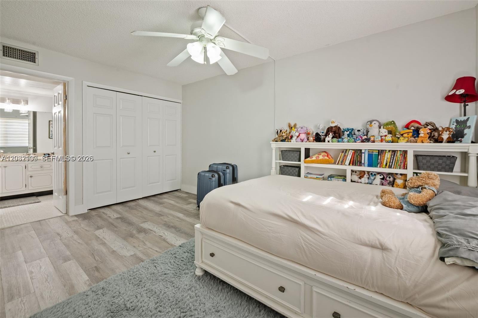 301 Racquet Club Road, Unit 104 Weston, FL 33326 - Photo 10 of 21 a bedroom with a bed and a chandelier