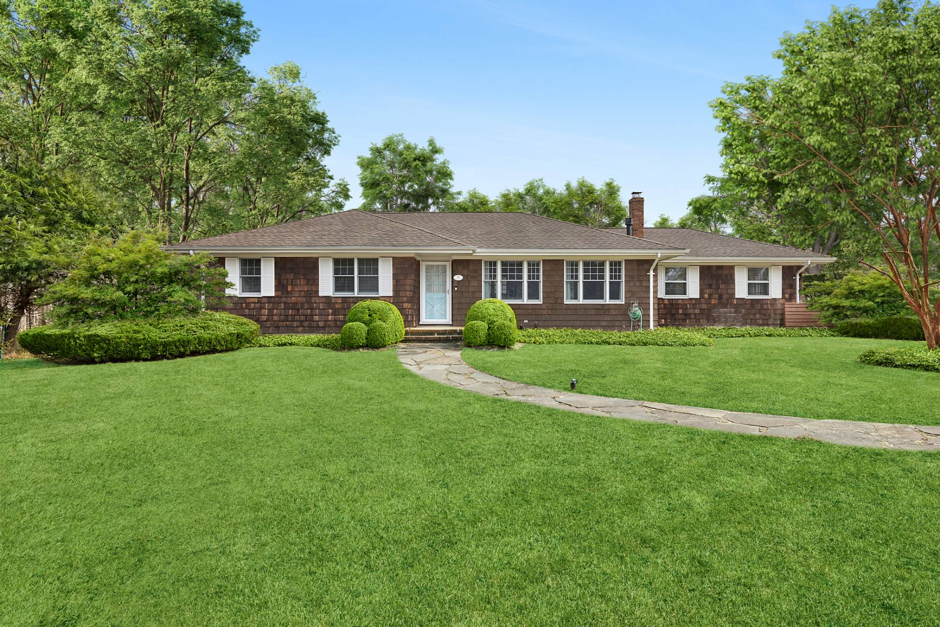 a front view of a house with a yard and green space