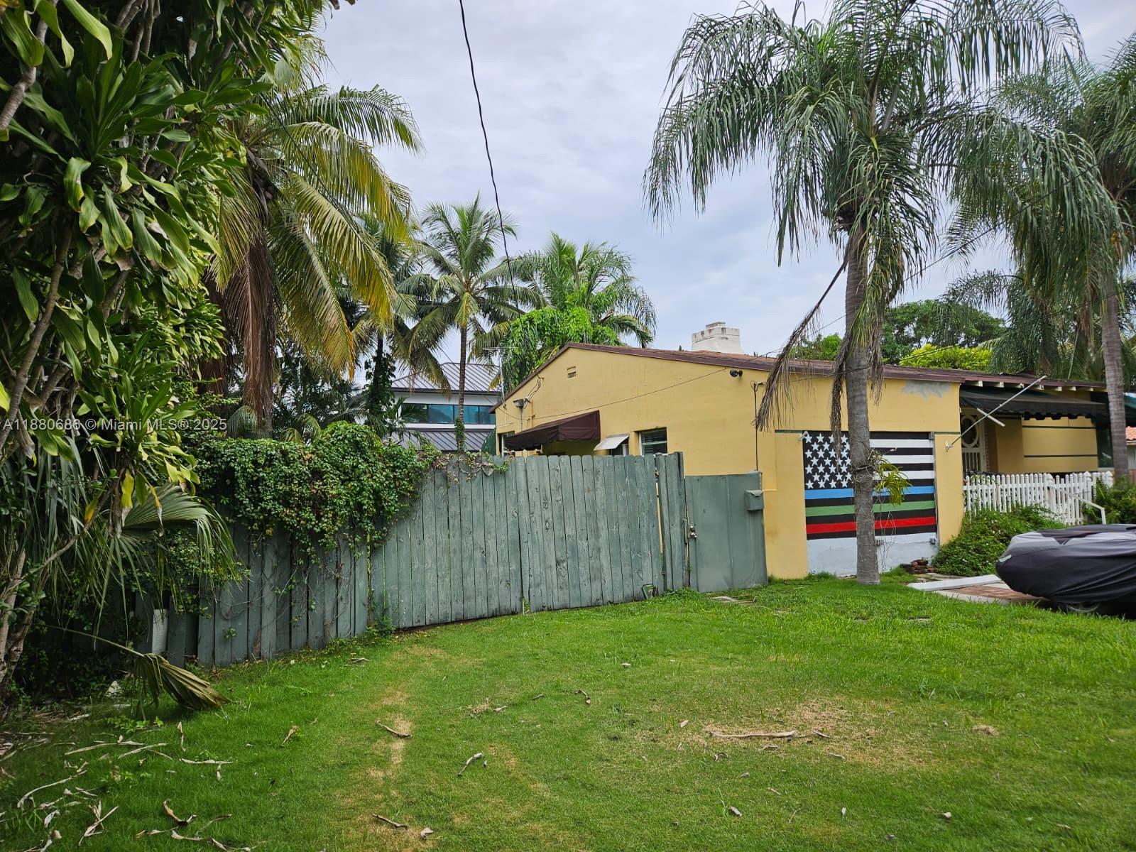 4021 Southwest 6th Street Miami, FL 33134 - Photo 8 of 14 a backyard of a house with potted plants and palm trees