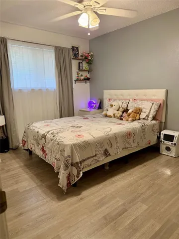 a bedroom with a bed chandelier and a dresser