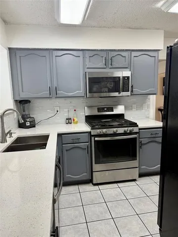 a kitchen with a sink stove and microwave