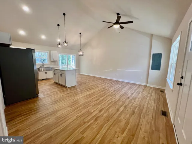 a view of a kitchen with wooden floor and a refrigerator
