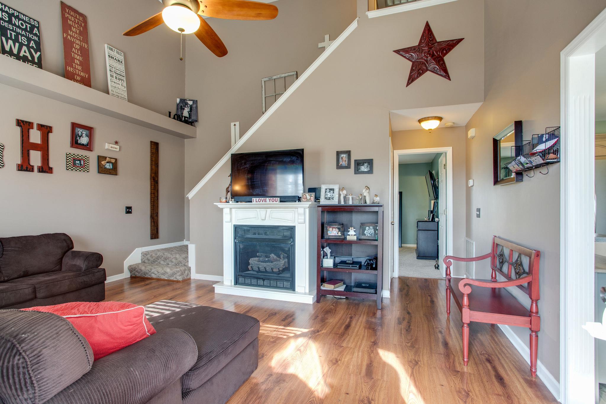 1967 Lasea Road Spring Hill, TN 37174 - Photo 2 of 30 a living room with furniture a flat screen tv and a fireplace