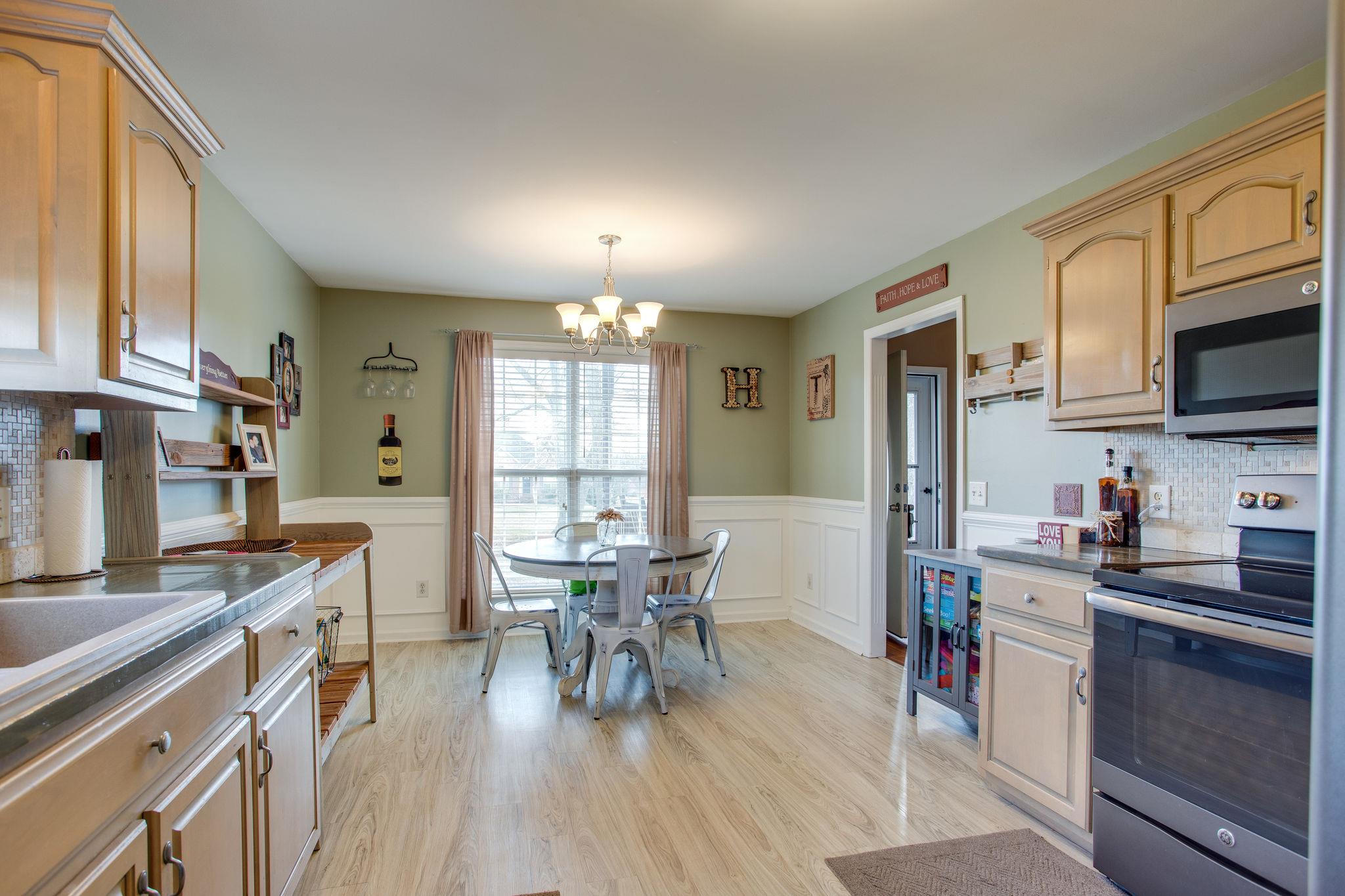 1967 Lasea Road Spring Hill, TN 37174 - Photo 11 of 30 a kitchen with stainless steel appliances a dining table chairs stove refrigerator and cabinets