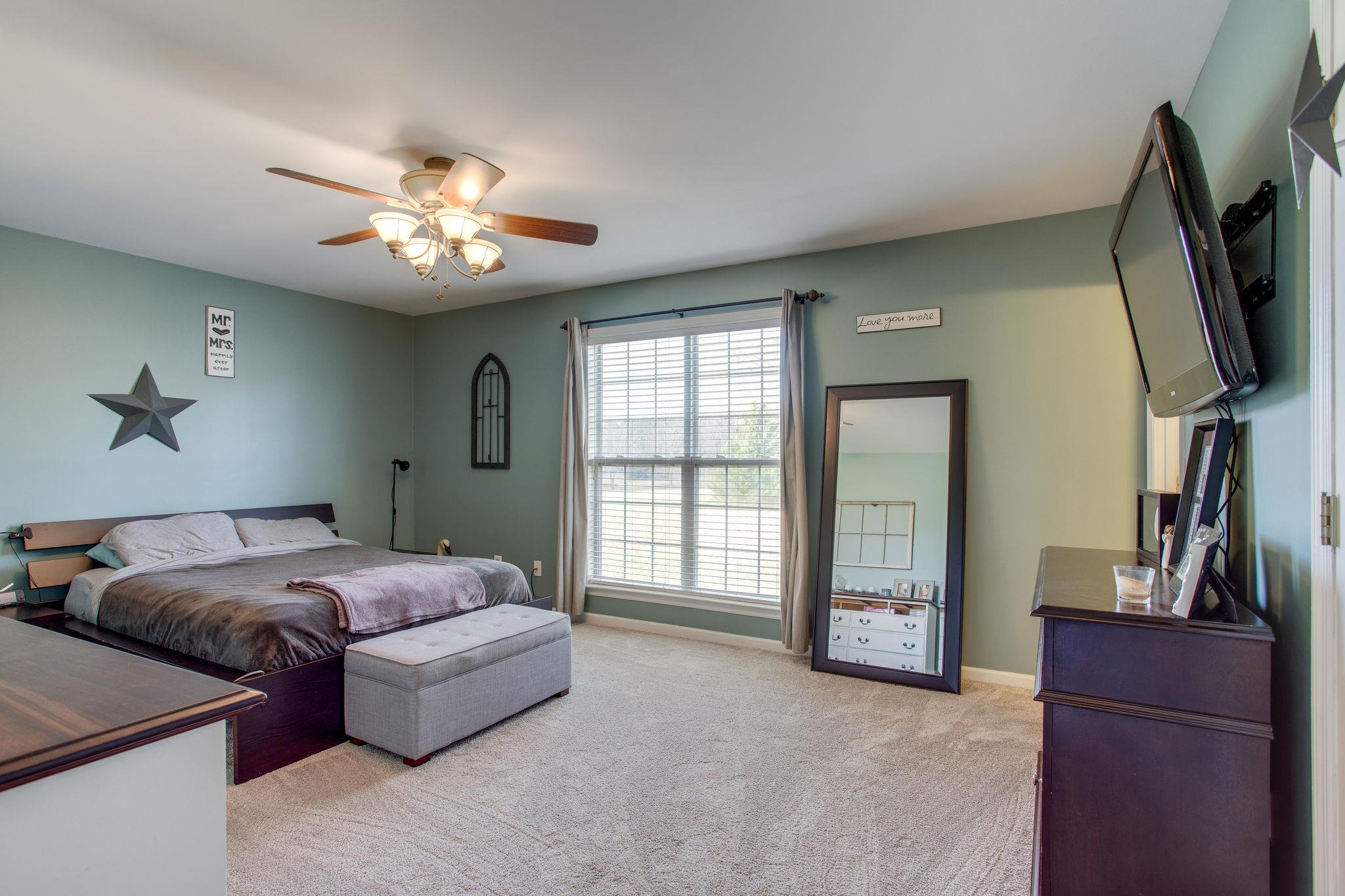 1967 Lasea Road Spring Hill, TN 37174 - Photo 13 of 30 a spacious bedroom with a bed and a flat screen tv