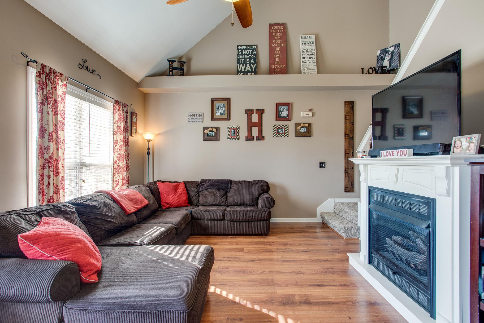 1967 Lasea Road Spring Hill, TN 37174 - Photo 5 of 30 a living room with furniture a flat screen tv and a fireplace