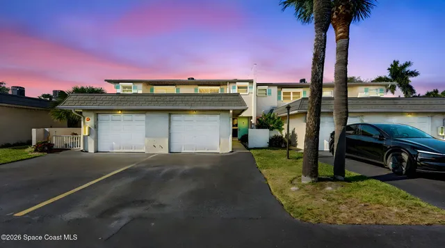 a front view of a house with a garden and yard