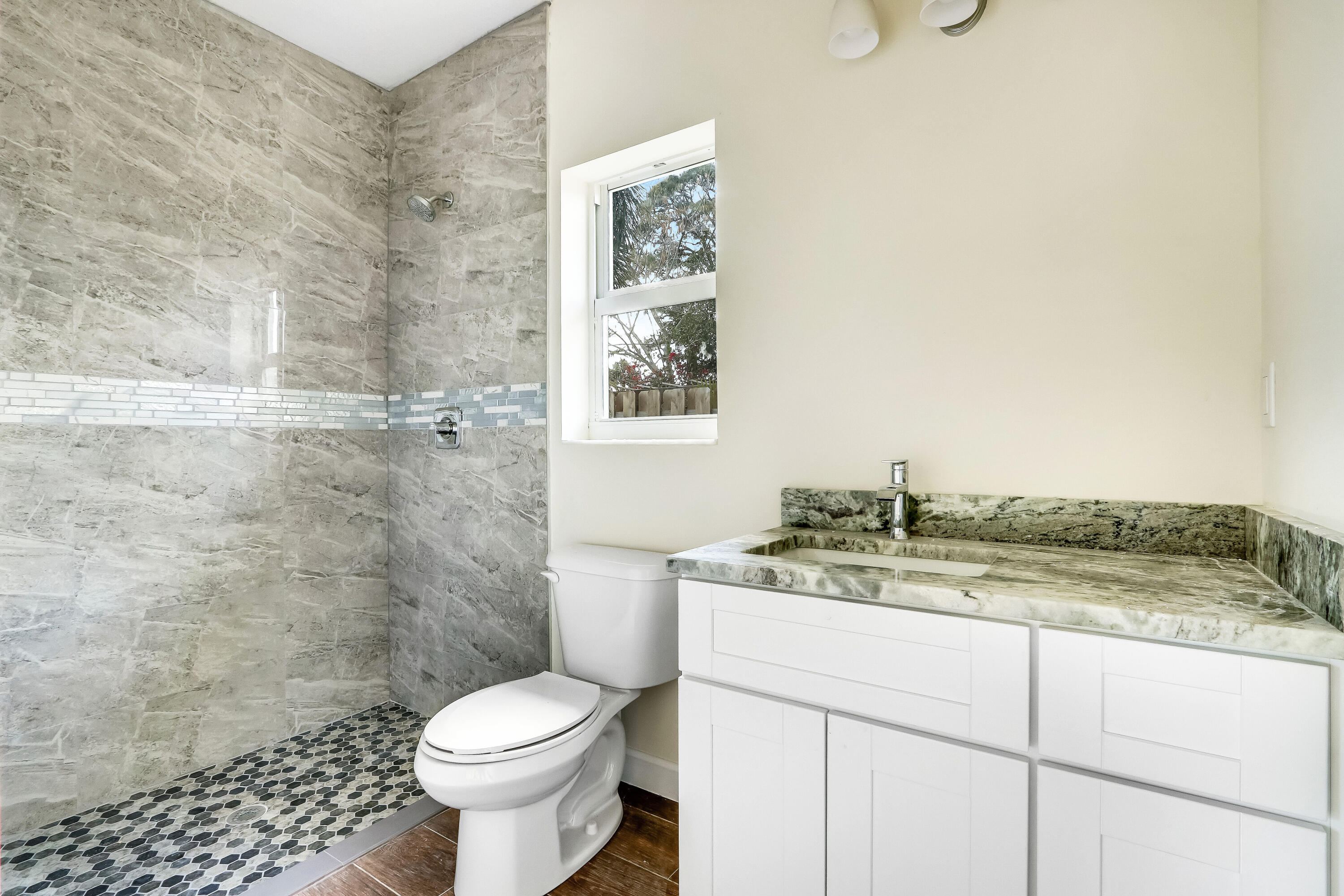 936 Southeast 6th Street Stuart, FL 34994 - Photo 20 of 25 a bathroom with a granite countertop toilet a sink and mirror