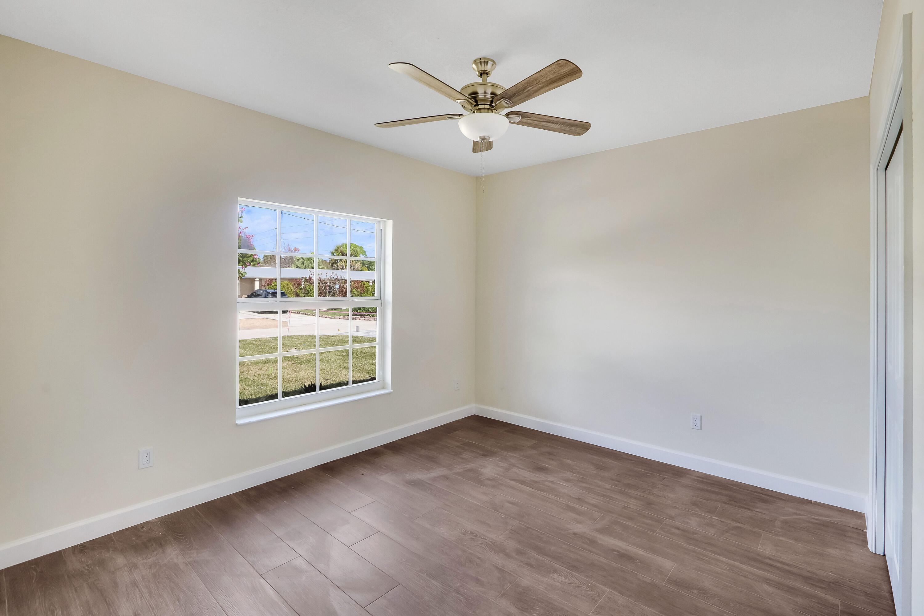 936 Southeast 6th Street Stuart, FL 34994 - Photo 21 of 25 an empty room with wooden floor and windows