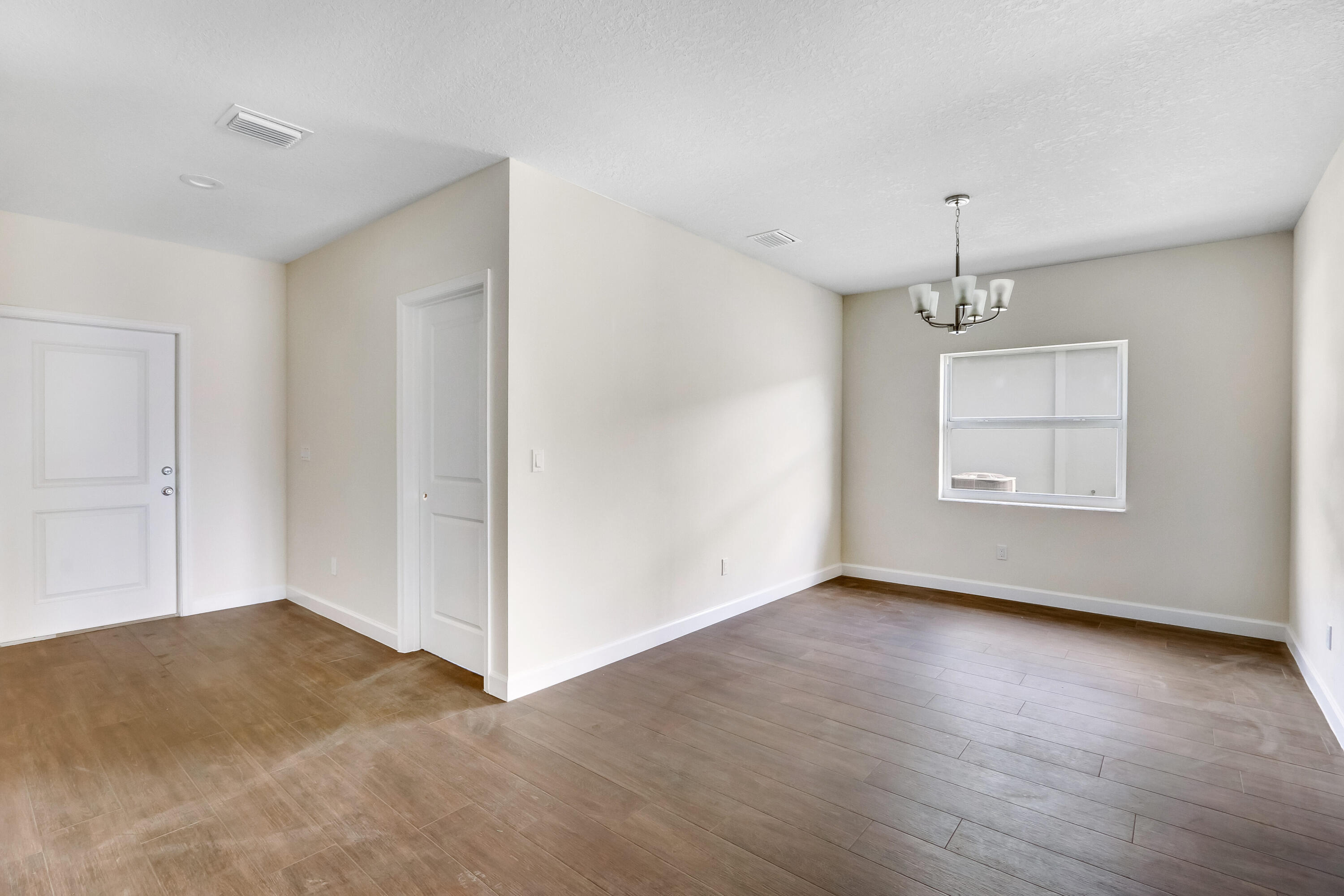 936 Southeast 6th Street Stuart, FL 34994 - Photo 10 of 25 a view of an empty room with window and wooden floor