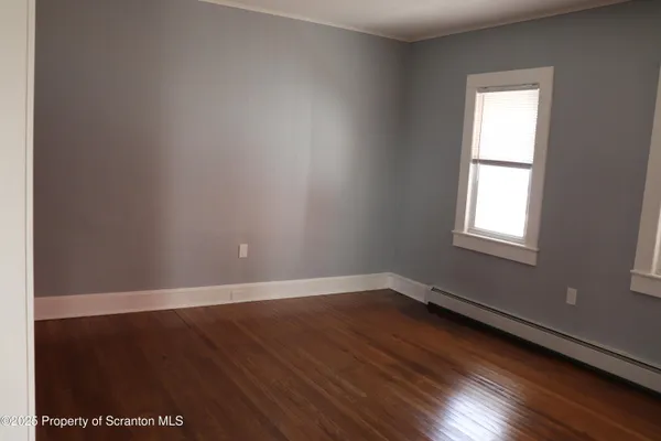 a view of staircase with wooden floor and white walls