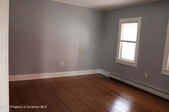 a view of staircase with wooden floor and white walls
