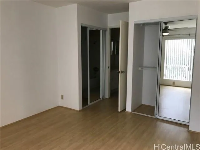 an empty room with closet and windows