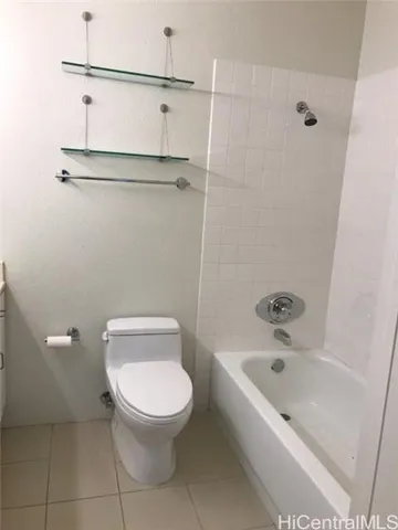 a white toilet sitting next to a bath tub
