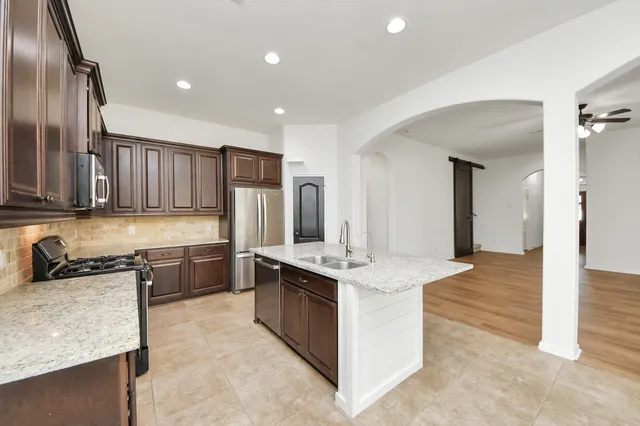 a kitchen with granite countertop a sink stove and refrigerator
