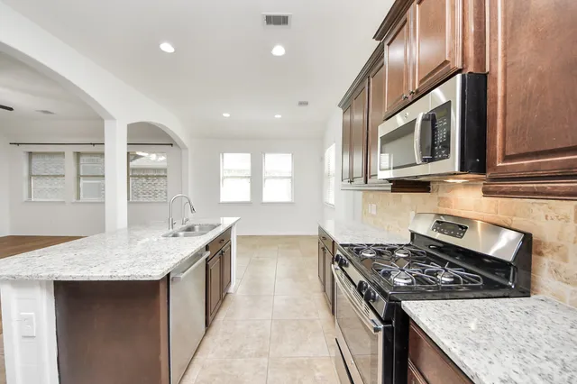 a kitchen with stainless steel appliances granite countertop a stove and a sink