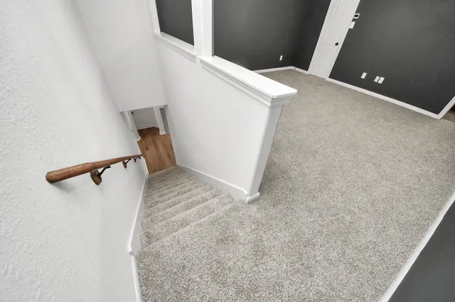 a view of an empty room with window and chandelier fan