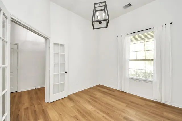 a view of empty room with wooden floor and window