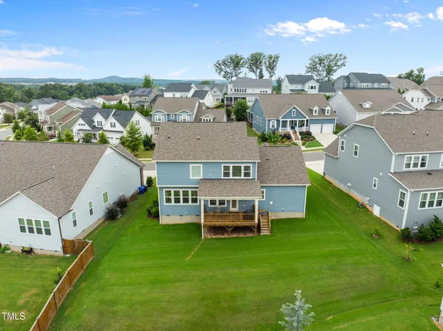 an aerial view of residential houses with outdoor space and seating