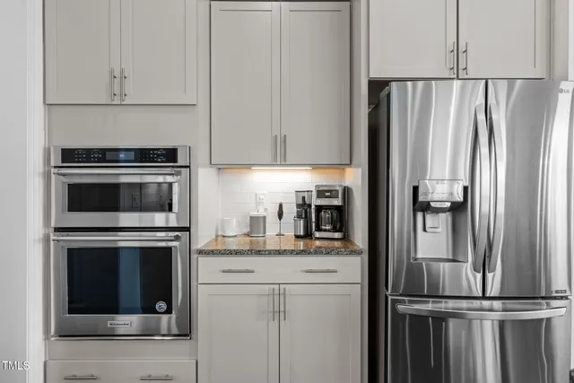 a kitchen with stainless steel appliances granite countertop a kitchen island a stove and a refrigerator