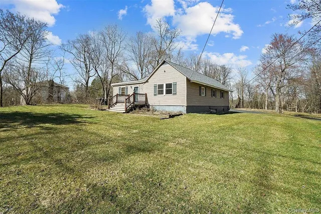 a house that is sitting in the grass with large trees