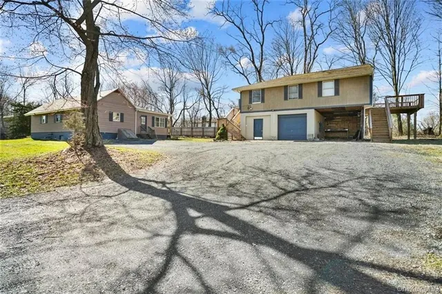 a front view of a house with a yard covered with snow